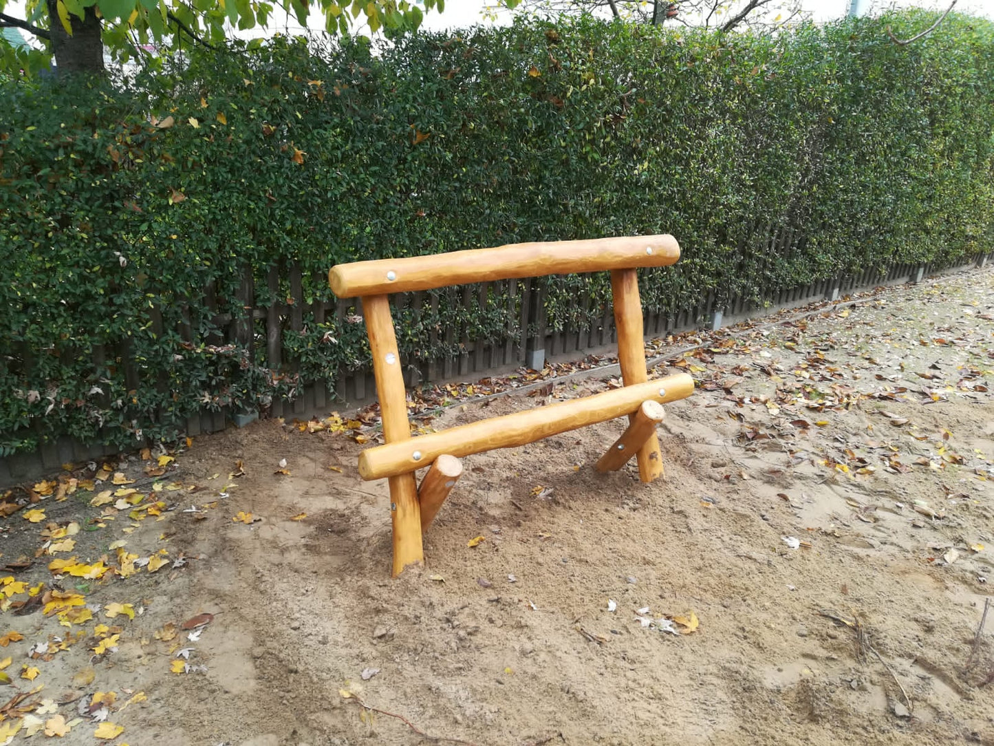 Klassische Jugendbank aus hellem Holz mit runder Sitzfläche und runder Lehne