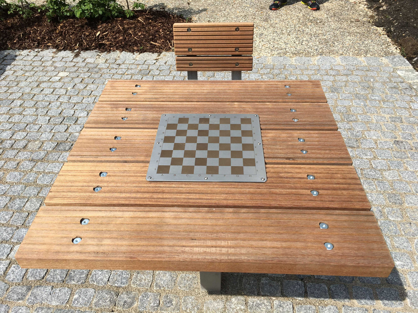 Spieltisch mit Schachfeld und einem Hocker mit Lehne