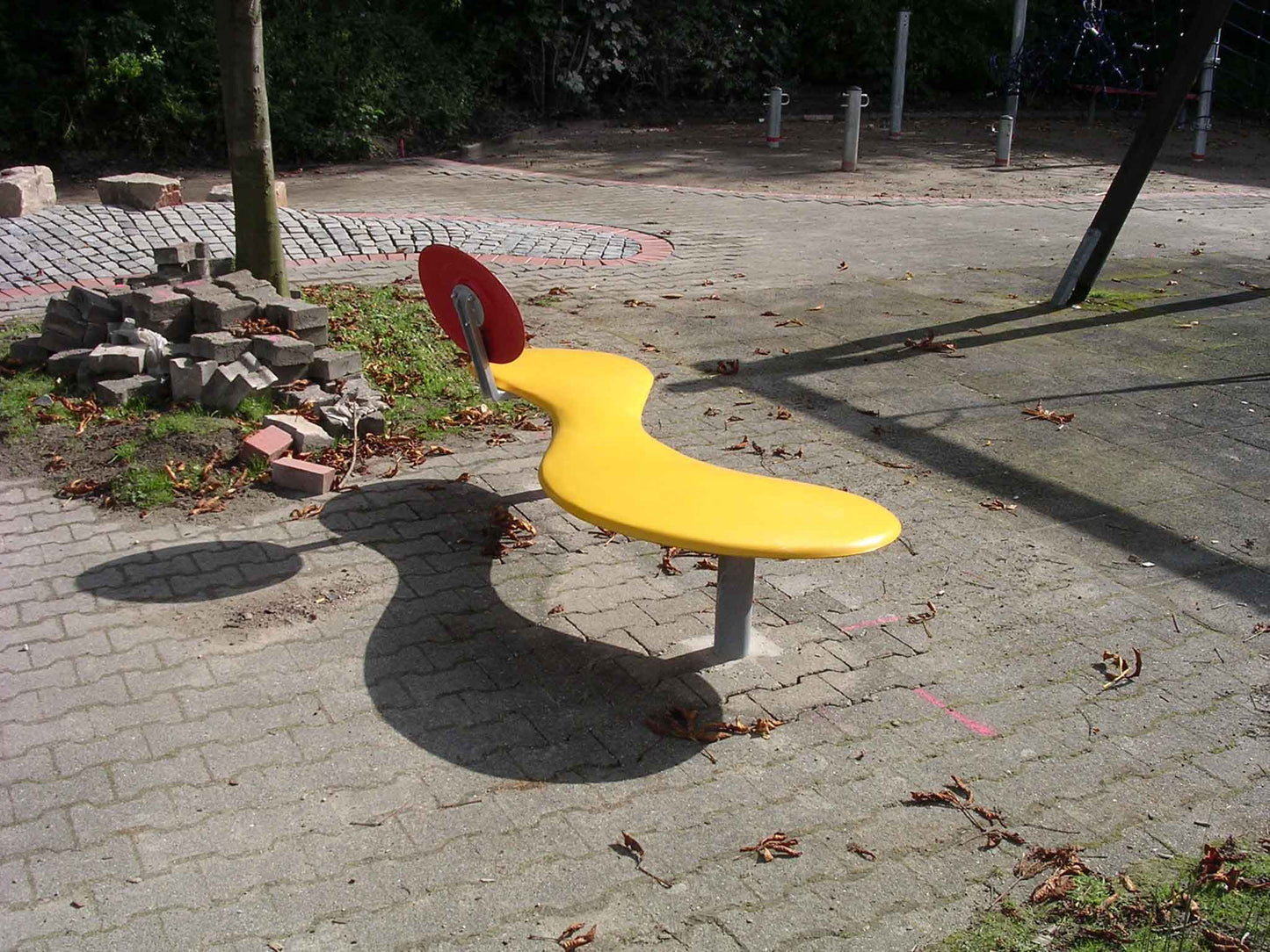 Eine gelbe Bank mit roter runder Lehne aus Kunststoff