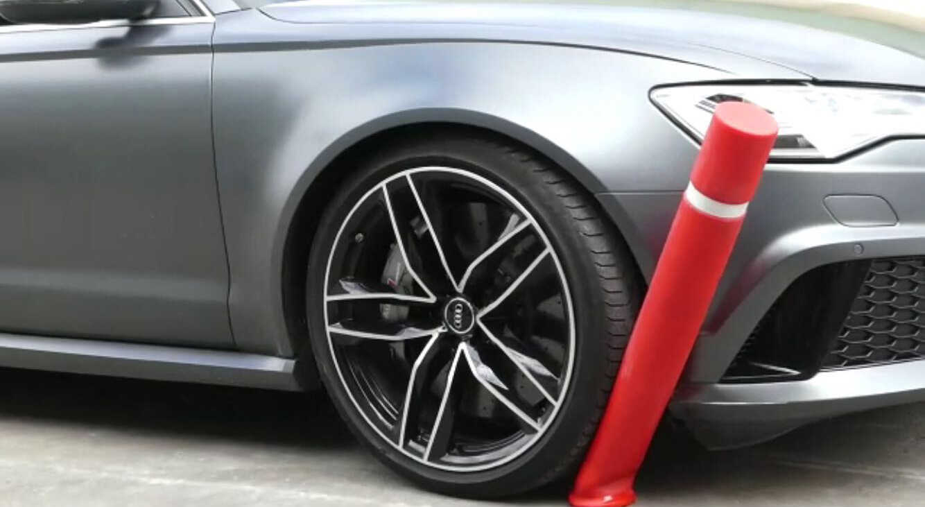 Ein silberner Audi fährt gegen einen roten Poller, der umknickt