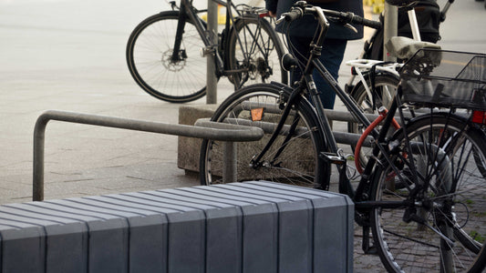 Eine Stadtbank aus Kunststoff mit einem Fahrradständer und Fahrrädern