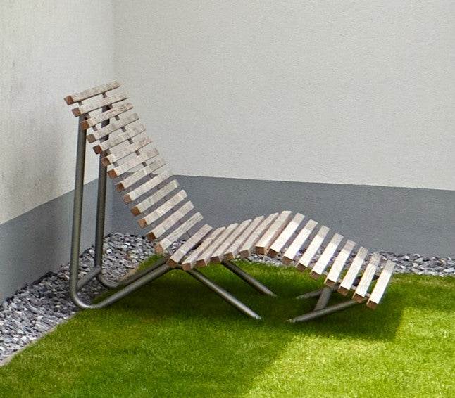 Relaxing Liege auf Rasen mit Wand im Hintergrund