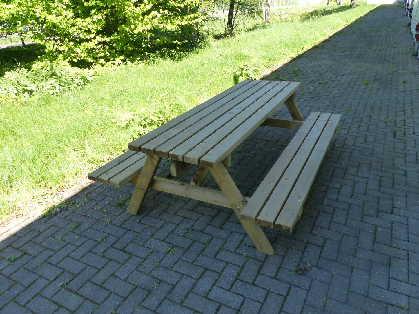 Moderne Bank-Tisch-Kombination aus Holz für den Park und Schulhof auf Pflasterstein